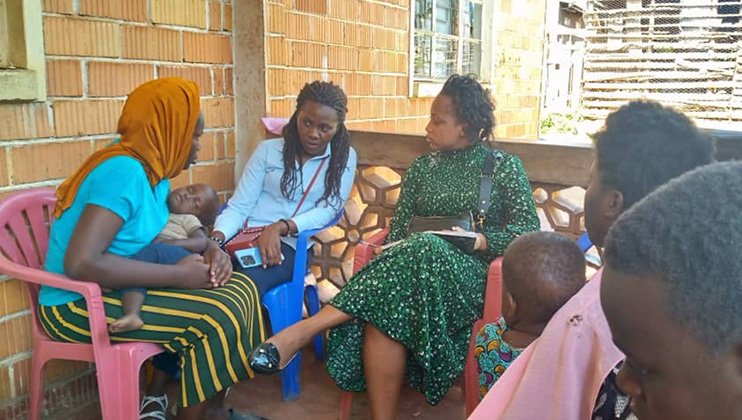 Women and children outside home talking